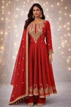 Woman wearing a red Banarasi Anarkali suit with gold embroidery and matching dupatta